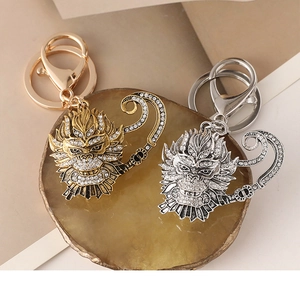 Macro detail of gold and silver Sun WuKong keychains with sparkling rhinestones