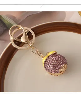Detail of purple rhinestone mangosteen keychain with gold hollow star base on a plate