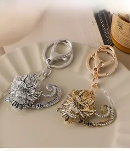 Detail view of dragon head keychains with inlaid rhinestones in gold and silver finish