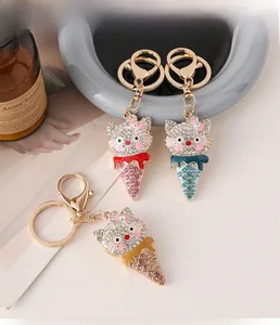 Macro detail of rhinestone-encrusted cartoon cat ice cream cone keychain with gold plating