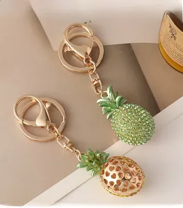 Close-up of sparkling green crystal pineapple keychain and golden heart cutout charm