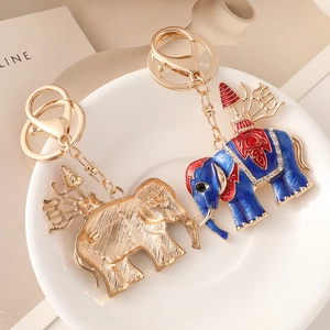 Porte-clés éléphant en émail bleu avec strass brillants sur une assiette en céramique