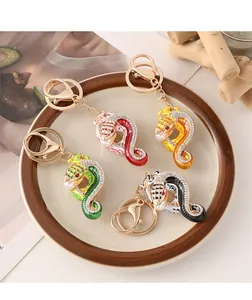 Vue détaillée des porte-clés serpent colorés avec strass en rouge, jaune, vert et noir mat