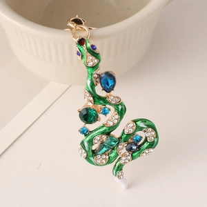 Porte-clés serpent vintage doré avec émail vert et cristaux brillants sur un bol