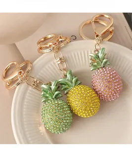 Close-up of sparkling rhinestone pineapple keychains in green, yellow, and pink colors