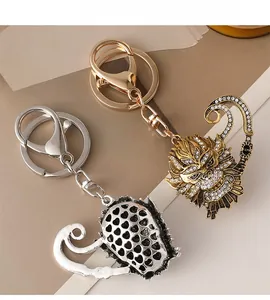 Detail of gold and silver Sun Wukong keychains with rhinestone inlay and hollow heart back