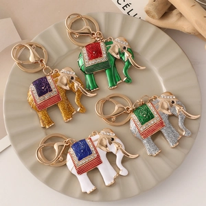 Colorful elephant enamel keychains with rhinestones and gold plating on a decorative plate