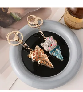 Detail of cartoon cat ice cream keychain with sparkling rhinestones and golden metal finish