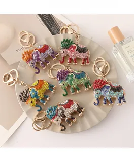 Detail of six colorful enamel elephant keychains with crystal rhinestones on a tray