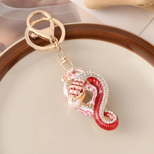 Porte-clés serpent créatif en métal doré avec cristaux colorés et détails en émail rouge