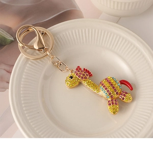 Dettaglio portachiavi a giraffa dorata con strass colorati su vassoio di ceramica