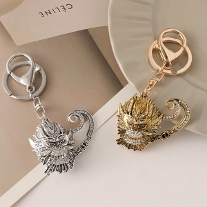 Golden and silver Sun Wukong metal keychains with rhinestones shown in top-down view