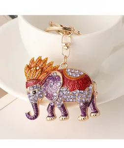 Detailed view of elephant keychain with purple rhinestones and colorful enamel on a white cup