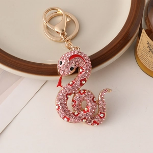 Porte-clés serpent en métal or rose avec strass roses et détails floraux en émail rouge