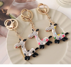 Detailansicht von drei Giraffen-Schlüsselanhängern mit Strass und Emaille auf Tablett