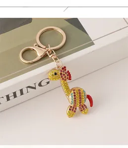 Dettaglio portachiavi a giraffa con strass colorati e chiusura dorata su libro