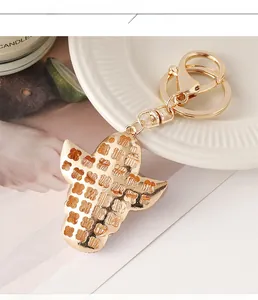Porte-clés tête de taureau doré avec motifs de trèfles évidés sur une assiette blanche