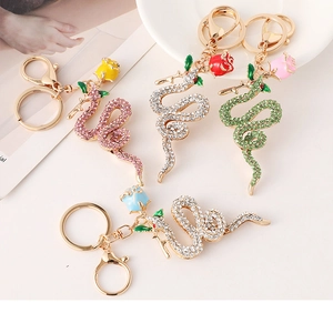 Detailed view of snake keychains with colorful rhinestones and rose flower charms