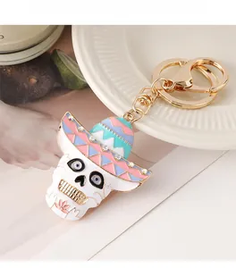 Détail d'un porte-clés tête de mort coloré avec sombrero et strass sur une assiette blanche