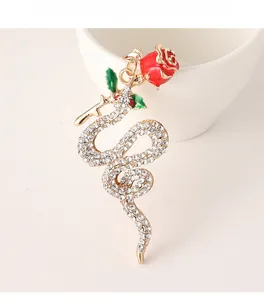 Macro detail of snake keychain with crystal rhinestones and a red enamel rose flower