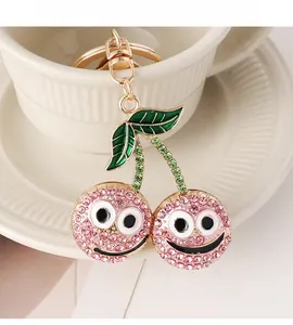 Detail of pink rhinestone cherry keychain with smiley face and gold hardware