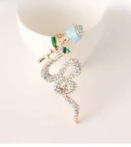 Close-up of snake and rose keychain with sparkling crystals and blue enamel detail