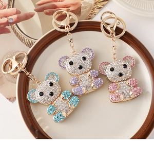 Detailed close-up of crystal teddy bear keychains in blue, purple and pink shiny colors