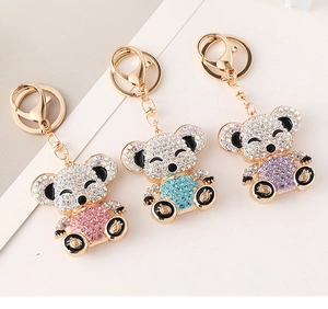 Close-up of bear keychains with pink blue and purple rhinestones on gold metal base