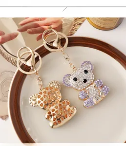 Detail of luxury rhinestone bear keychain and gold metal bear charm on ceramic plate