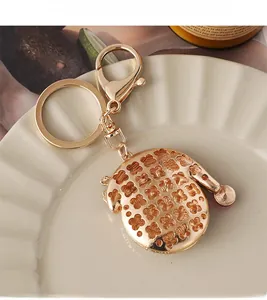 Detailed close-up of golden hollow clover pattern pendant on a stylish metal keychain