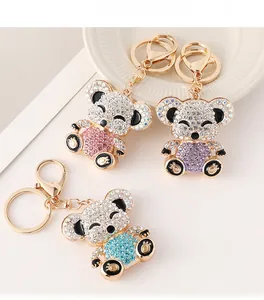Macro detail of three crystal teddy bear keychains in pink, blue, and purple hues