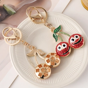 Creative rhinestone cherry keychain with smiley face and gold floral metal pendant