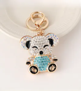 Close-up of gold koala keychain with white and blue rhinestones on a white plate