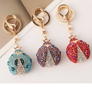 Detail view of beetle keychains with rhinestone inlay in blue, purple and red colors