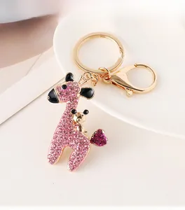 Detailed close-up of a pink rhinestone giraffe keychain with golden bear motif and hook