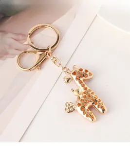 Detailed view of a gold giraffe keychain with hollow heart patterns on a stylish postcard