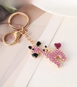 Detail of a gold alloy giraffe keychain with pink rhinestones and a heart-shaped crystal