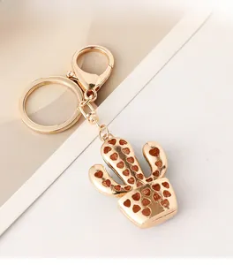 Detail of a golden cactus keychain with heart cutouts and a secure lobster clasp