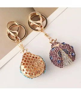Detailed views of ladybug keychain showing sparkling purple rhinestones and golden mesh back