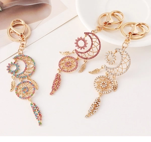 Detail of moon and sun dreamcatcher keychains with sparkling rhinestones and gold plating