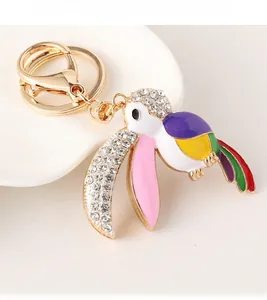 Détail du porte-clés toucan coloré avec cristaux brillants sur porcelaine blanche