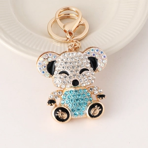 Sparkling koala keychain with blue rhinestones and gold plating on white background