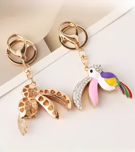 Détail d'un porte-clés toucan coloré avec cristaux et découpes en forme de cœur