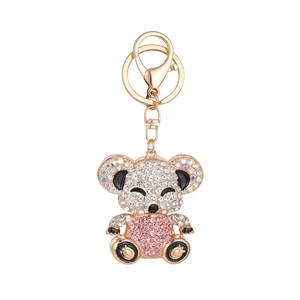 Sparkling koala keychain in gold metal with pink and white rhinestones on white background