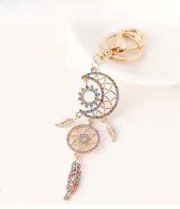 Detail of moon dreamcatcher keychain with colorful rhinestones and golden feathers