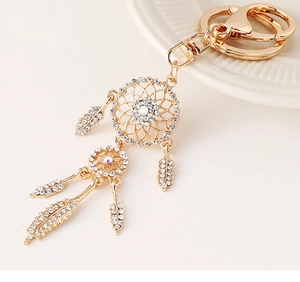 Detail view of golden dreamcatcher keychain featuring crystal rhinestones and feather charms