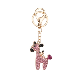 Pink rhinestone deer keychain with a golden bear and heart-shaped tail accent