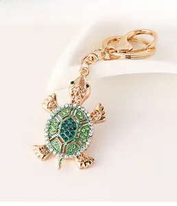 Detailed view of turtle keychain with sparkling green rhinestones and golden metal hardware