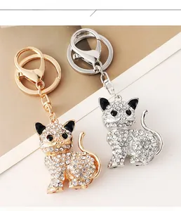 Dettaglio macro di portachiavi a forma di gatto con strass in oro e argento e moschettone