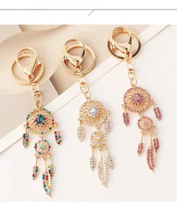 Detailed close-up of golden dreamcatcher keychain with rhinestones and feather pendants